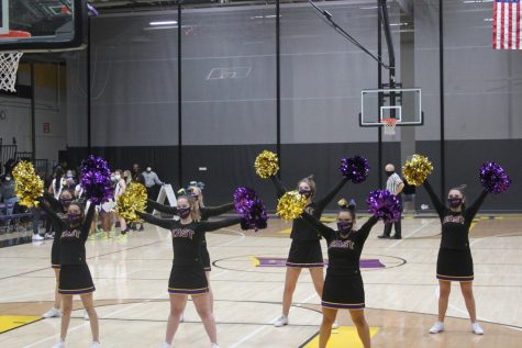 East’s cheer team performs at half-time. The Cheerleaders split their time by performing at about half of the girls’ basketball games and half of the boys’ games.