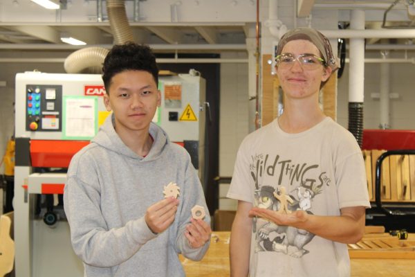 Woods 3 and 4 students, juniors Muacheng Thao and Henry Riley, show off some of the small wooden objects they've made that will be hidden around the school as part of a sort of school wide scavenger hunt. Students can look for the items Oct. 20-31, and for those who find one, bring it to room G417 (the Woodshop) to turn it in for a small prize.